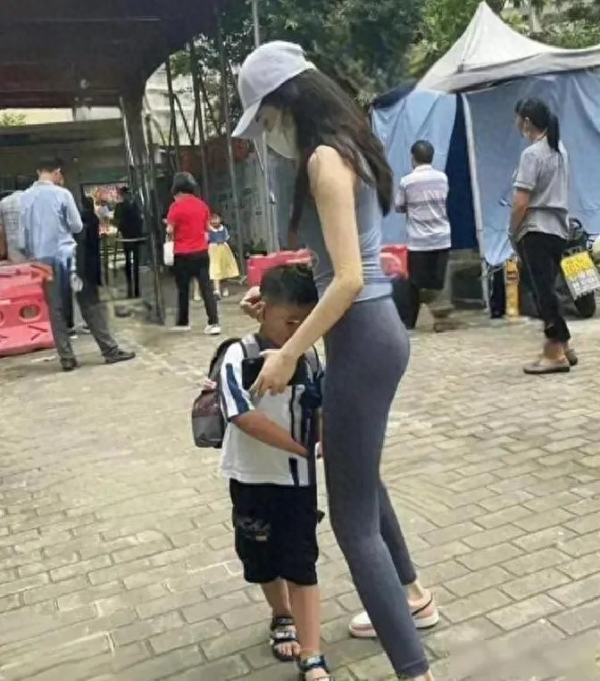 河南女子穿瑜伽裤接孩子男家长回头张望网友：这打扮不合适(图1)